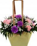 Красивый и практичный подарок - букет в сумке, состоящий из двух цветов гвоздики и сантина, дополненный зеленью и вставленный в красивый подарочный па